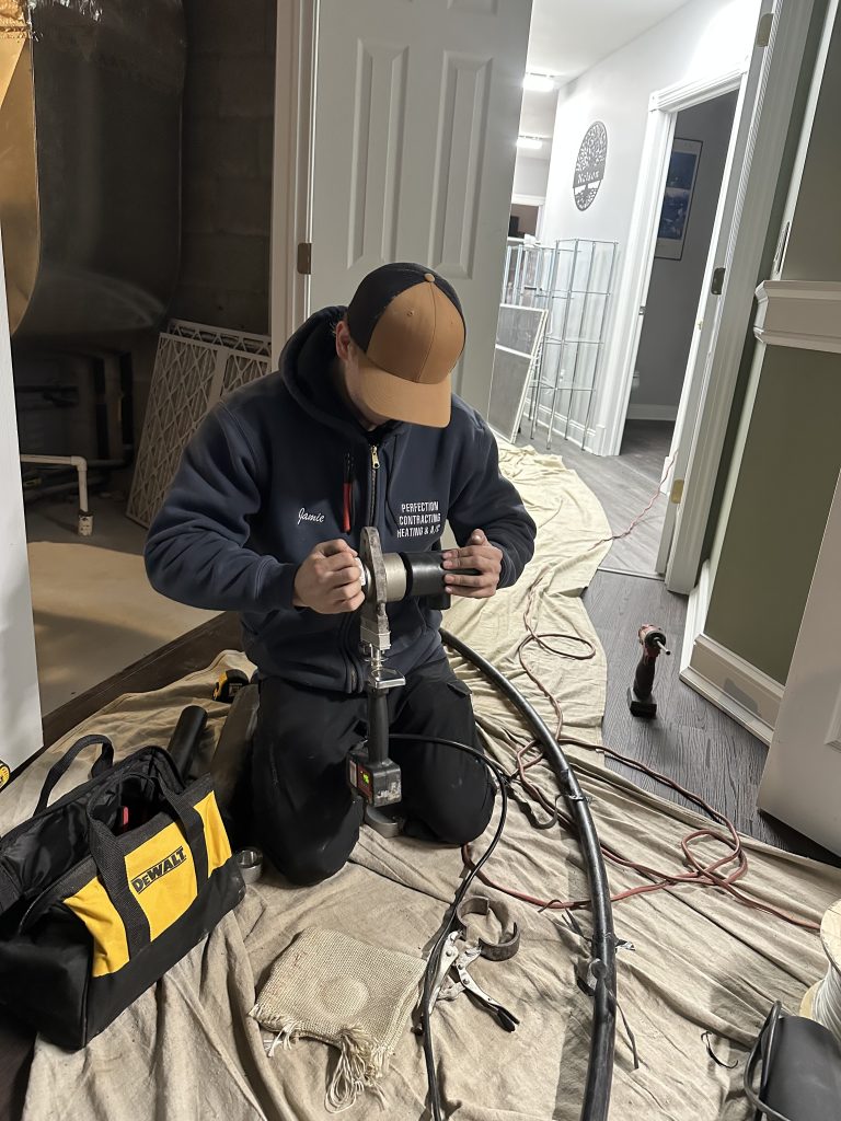 Technician from Perfection Contracting installing ductless HVAC system in New Jersey home.