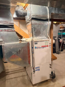 Furnace in a basement with ductwork, illustrating how it heats homes in New Jersey during winter