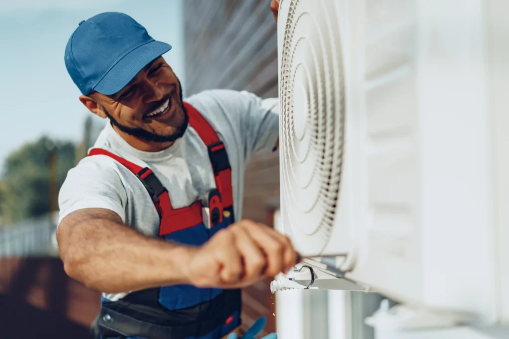 Technician checking an outdoor heat pump unit during a maintenance visit